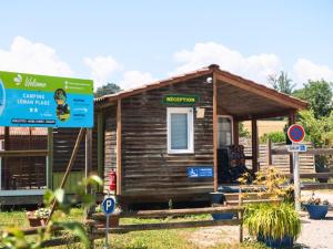 a small wooden house with a sign in front of it at Camping Léman Plage in Excénevex