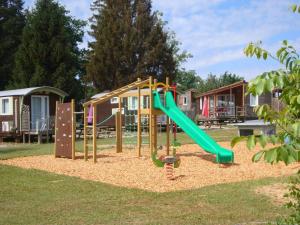 a playground with a green slide in a park at Camping Léman Plage in Excénevex +31 photos