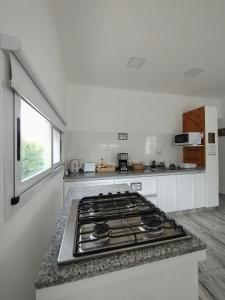 a white kitchen with a stove top oven at Casa con jardín Las Marías 1 in Miramar