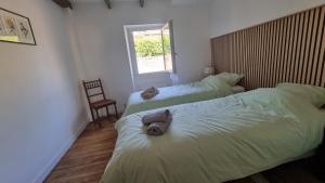 a bedroom with two beds with towels on them at Maison de Pierre in Septfonds