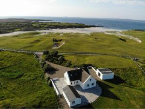 an aerial view of a house and the ocean at Doonloughan View, Ballyconneely in Ballyconneely