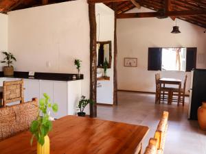 a living room with a wooden table and a dining room at Vila Riomar in Luis Correia