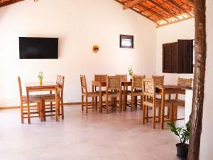 a dining room with wooden tables and chairs at Vila Riomar in Luis Correia