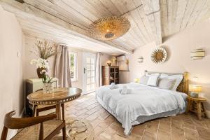 a bedroom with a large bed and a table at Maison Casasand Maison d'hôtes de charme in Grasse