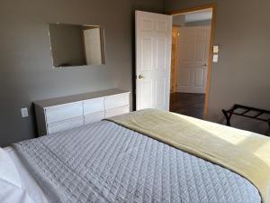 a bedroom with a bed with a blue comforter at The Sunshine Inn in Parrsboro