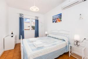 a white bedroom with a bed and a window at Villa Mares in Cala en Porter +9 photos