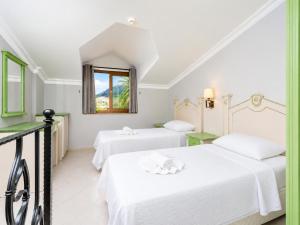 two beds in a white room with a window at Villa Deniz Paradise in Dalyan +57 photos