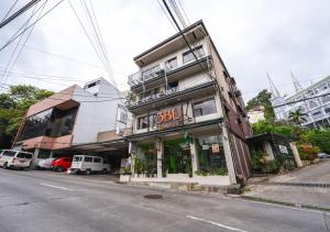 a building with a sign on the side of a street at 3BU Hostel Baguio - Bonifacio in Baguio