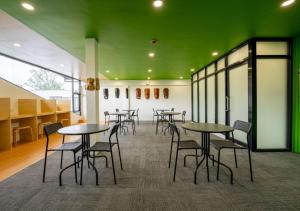 a group of tables and chairs in a room with green ceilings at 3BU Hostel Baguio - Bonifacio in Baguio