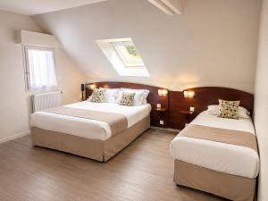 a bedroom with two beds and a skylight at Kyriad Saint-Malo Dinard in La Richardais +29 photos
