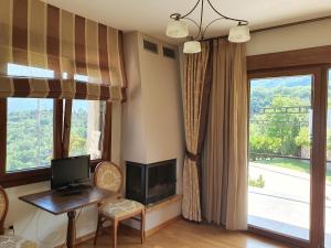 a living room with a desk and a television and a window at Guesthouse Thea in Naousa