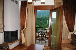 a living room with a view of a table and a fireplace at Guesthouse Thea in Naousa