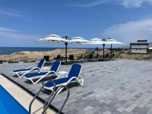 a group of blue and white chairs and umbrellas at Ton Azure Hotel in Tong