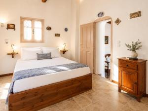 a bedroom with a large bed and a wooden dresser at Villa Antigoni in Alikias