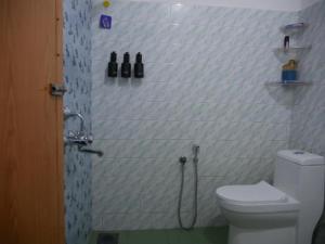 a bathroom with a shower and a toilet in it at Temple Courtyard in Chengannūr