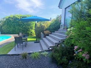 a patio with an umbrella and a table and chairs at Côté Cosy in Marche-en-Famenne