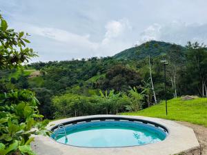 a swimming pool with a mountain in the background at Finca Lantana Oficial in Villeta