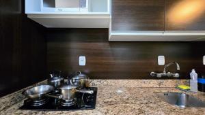 a kitchen counter with pots and pans on a stove at Baviera Studio Canela in Canela +21 photos