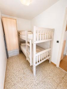 two white bunk beds in a room with a door at Les cases del vent I in L'Ametlla de Mar