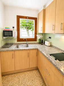 a kitchen with a sink and a microwave at Les cases del vent I in L'Ametlla de Mar +8 photos