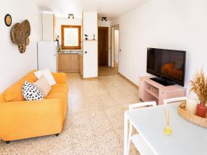 a living room with a couch and a tv at Les cases del vent I in L'Ametlla de Mar