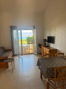 a living room with a table and a view of the ocean at Résidence Figarella in Propriano