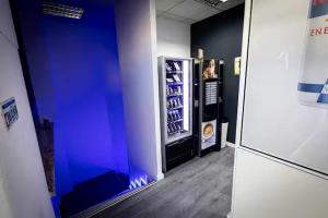 a blue room with a refrigerator with drinks in it at CyberHostel Almada in Almada