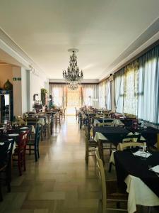 a dining room with tables and chairs and a chandelier at HOTEL CONCORDIA in Montecatini Terme