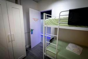 a room with two bunk beds and a door at CyberHostel Almada in Almada +20 photos