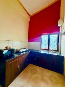 a kitchen with a sink and a red wall at Shiva Valley Retreat in Calangute