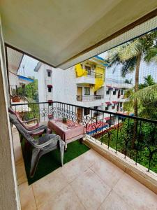 a balcony with a table and chairs and a pool at Shiva Valley Retreat in Calangute