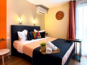 a bedroom with a bed with a tray of towels at Hôtel L'Etoile Aéroport - A61 in Carcassonne