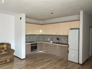 a kitchen with brown cabinets and a white refrigerator at LakeView Pogradec in Pogradec