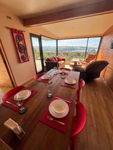 a dining room with a table with red chairs and a view at Cabañas Vista Volcanes del Sur in Llanquihue