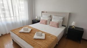 a bedroom with a large bed with two towels on it at LUCINDA`S HOUSE in Braga