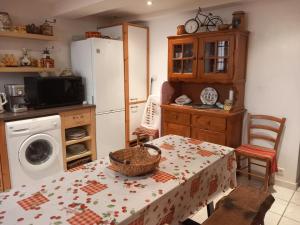 a kitchen with a table and a refrigerator at La Petite Maison de Caractere Catalan in Argelès-sur-Mer