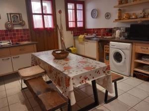 a kitchen with a table and a washing machine at La Petite Maison de Caractere Catalan in Argelès-sur-Mer