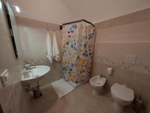 a bathroom with a toilet sink and a shower curtain at Casa de' Vestini in Fossa +19 photos