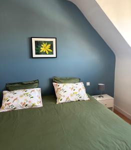 a bedroom with a green bed with two pillows at Ty-Aganisia Breizh in Perros-Guirec