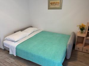 a bedroom with a bed with a green blanket at Villa Pinija in Fažana