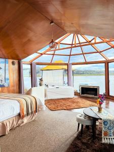 a bedroom with a large room with a bed and a tub at KAY PACHA LODGE Uros in Puno