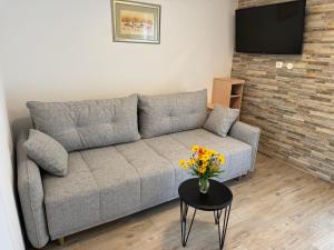 a living room with a couch and a table with flowers at Villa Pinija in Fažana
