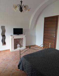 a bedroom with a bed and a tv on a wall at Casa de' Vestini in Fossa
