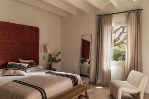 a bedroom with a bed and a chair and a window at Hotel Sant Ignasi in Ciutadella +48 photos