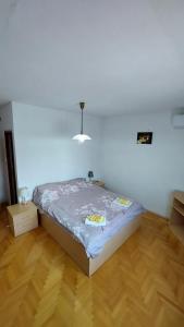 a bed in a room with a wooden floor at Zdravo Homolje in Petrovac na Mlavi +30 photos