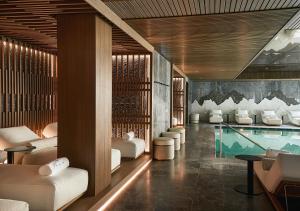 a hotel lobby with a swimming pool and chairs at Grand Hotel Ampezzo in Cortina dʼAmpezzo