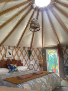 a bedroom in a yurt with a bed and a window at Le Cocon de Tranquillité au Cœur de la Campagne in Les Pégués