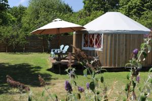 a gazebo with chairs and an umbrella in a yard at Le Cocon de Tranquillité au Cœur de la Campagne in Les Pégués