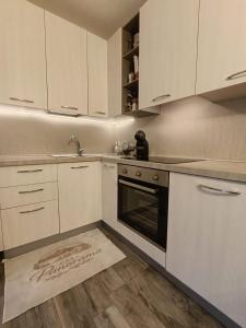 a kitchen with white cabinets and an oven and a rug at Casa Panorama Intelvi - Como & Lugano Lakes in Laino +21 photos