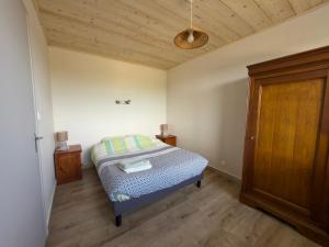 a bedroom with a bed and a wooden ceiling at Gîte Le p'tit Chasseral in Maîche
